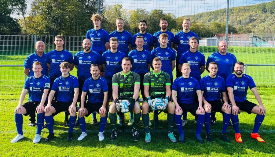 Die Spieler einer Fußballmannschaft stehen zusammen und lächeln für ein Teamfoto.