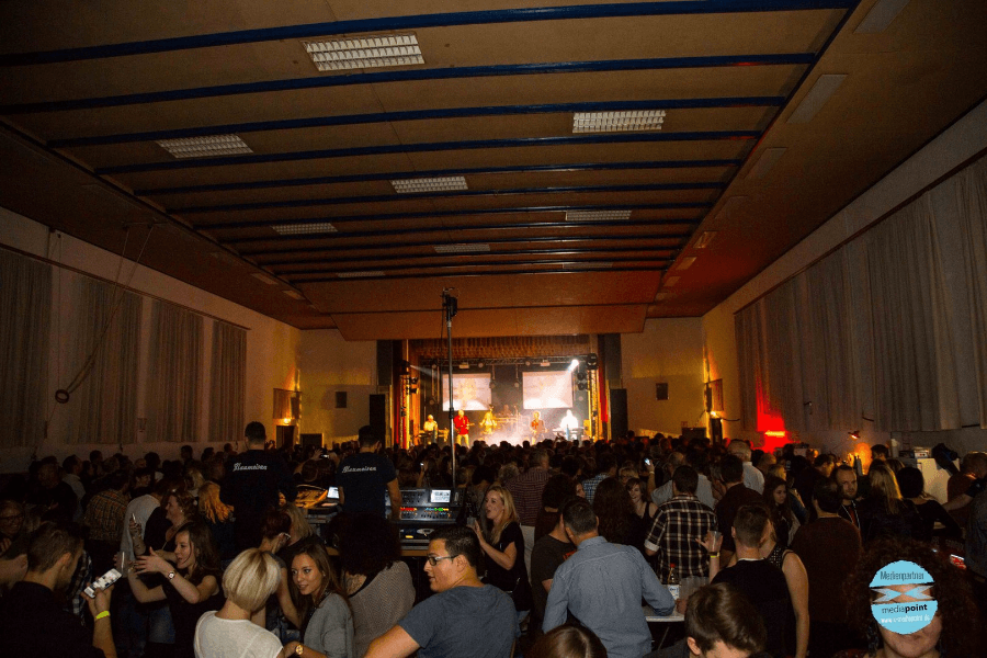 Eine Vielzahl von Personen füllt einen großen, offenen Veranstaltungsraum.