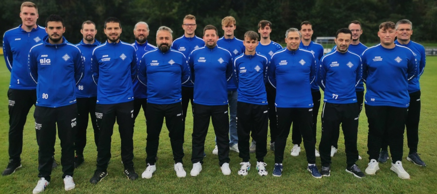Männer in blauen Shirts versammeln sich auf einem offenen Feld.